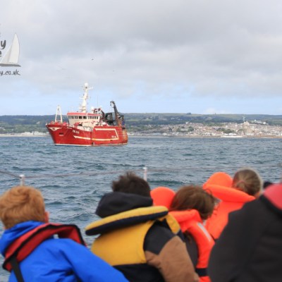 children watching fishing boat