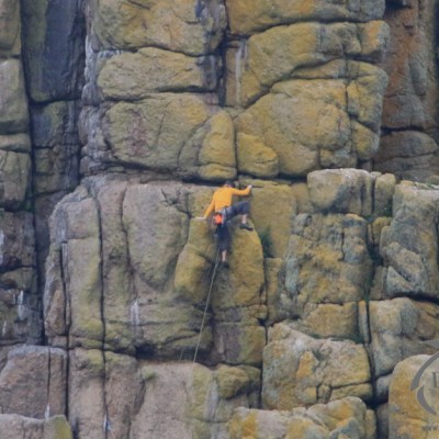 Climber climbing sea cliffs