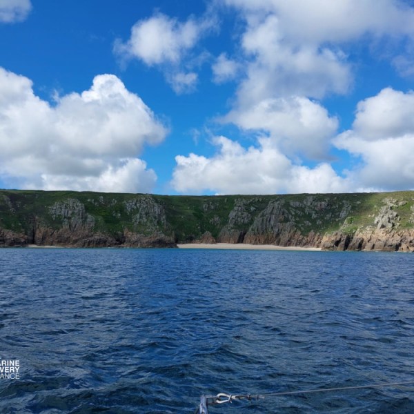 Cliffs and blue sky above calm sea on a sunny day.