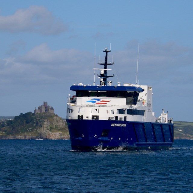 Blue ferry boat on the sea with distant island and castle.